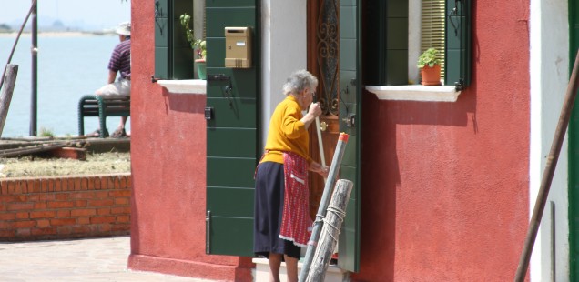 older lady sweeping outside